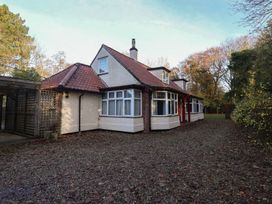 An exterior view of a house with gravel driveway and trees at The Anchorage in 