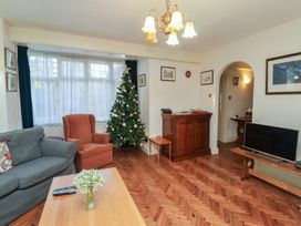 A living room with a Christmas tree and a television at The Anchorage