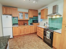 A kitchen with wooden cabinets and appliances at The Anchorage