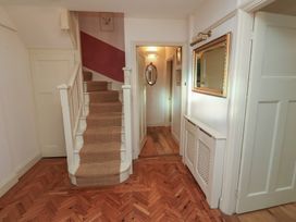 A hallway with a staircase and a mirror at The Anchorage