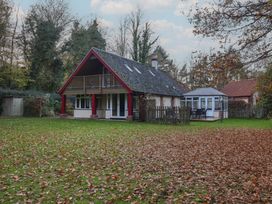 A house with a balcony and conservatory in a green garden at The Anchorage