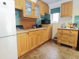 A kitchen with wooden cabinets and appliances at The Anchorage in Hoveton & Wroxham