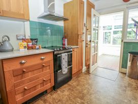 A kitchen featuring a cooker, cabinets, and a door leading to another room at The Anchorage in Hoveton & Wroxham