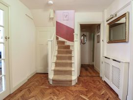 A hallway with a staircase and mirror at The Anchorage in Hoveton & Wroxham
