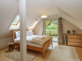 A bedroom with a bed and windows at The Anchorage in Hoveton & Wroxham