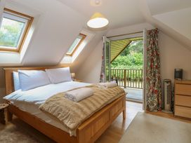A bedroom with a bed and sliding door at The Anchorage in Hoveton & Wroxham