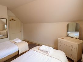 A bedroom with twin beds and a dresser at The Anchorage in Hoveton & Wroxham