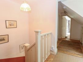 A hallway with stairs and paintings at The Anchorage in Hoveton & Wroxham