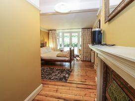A bedroom with a bed, curtains, and a window at The Anchorage in Hoveton & Wroxham