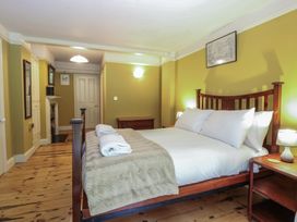 A bedroom with a bed and a bedside table at The Anchorage in Hoveton & Wroxham