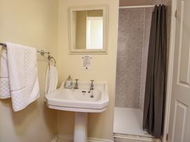 A bathroom with a sink, mirror, and shower at The Anchorage in Hoveton & Wroxham