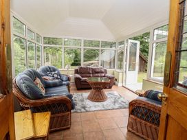 A conservatory with seating and glass walls at The Anchorage in Hoveton & Wroxham