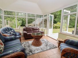 A conservatory with seating and a coffee table at The Anchorage in Hoveton & Wroxham
