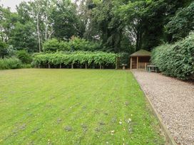 A garden with grass and a gazebo at The Anchorage in Hoveton & Wroxham