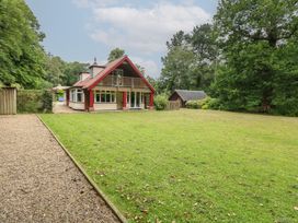 A house surrounded by grass and trees at The Anchorage in Hoveton & Wroxham