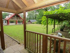 A garden with a house and wooden pergola at The Anchorage in Hoveton & Wroxham