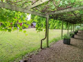 A garden featuring a grapevine trellis and planters at The Anchorage in Hoveton & Wroxham