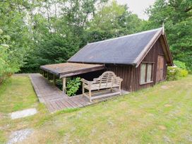 A wooden cabin with a porch and bench at The Anchorage in Hoveton & Wroxham