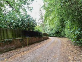 A gravel path with a fence and trees at The Anchorage in Hoveton & Wroxham