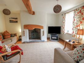 A living room with a fireplace and television at St John's House in Newport, Pembrokeshire