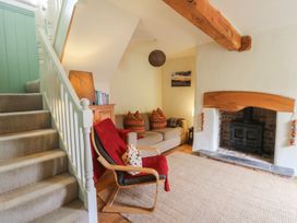 A living room with a staircase and a fireplace at St John's House, Newport, Pembrokeshire