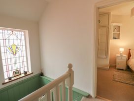 A hallway with a stained glass window and a door leading to a bedroom at St John's House Newport, Pembrokeshire