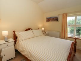 A bedroom with a bed and nightstand at St John's House, Newport, Pembrokeshire
