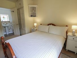 A bedroom with a bed and a nightstand at St John's House, Newport, Pembrokeshire