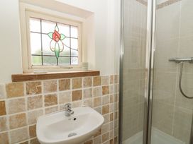 A bathroom featuring a shower and a washbasin at St John's House, Newport, Pembrokeshire