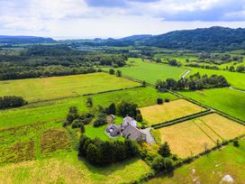 An aerial view of a house surrounded by fields and trees at Grove House in Grange-Over-Sands