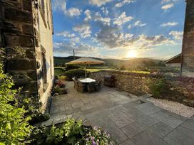 An outdoor seating area with a table and chairs at Grove House in Grange-Over-Sands