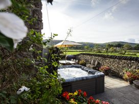 A garden with a hot tub and seating area at Grove House in Grange-Over-Sands