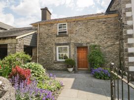 A stone house with flowers in the garden at Grove House in Grange-Over-Sands