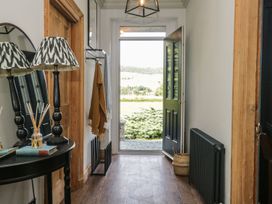A hallway with a table and lamp at Grove House in Grange-Over-Sands