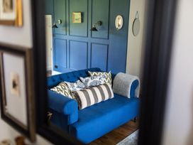 A living room with a blue sofa and decorative pillows at Grove House in Grange-Over-Sands