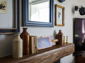 A living room with decor including vases and books at Grove House in Grange-Over-Sands