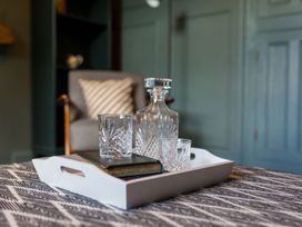 A tray with a decanter, glasses, and a book in a living room at Grove House in Grange-Over-Sands