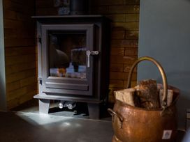 A wood stove and a basket of firewood at Grove House in Grange-Over-Sands