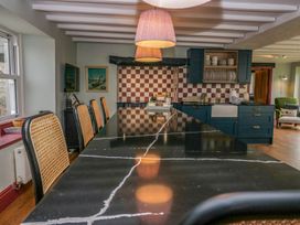 A kitchen with a large island and seating at Grove House in Grange-Over-Sands