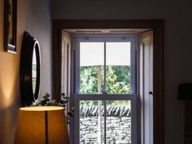 A hallway with a window and lamp at Grove House in Grange-Over-Sands