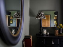 A room with a lamp, mirror, and picture frames at Grove House in Grange-Over-Sands