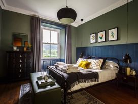 A bedroom with a bed and a dresser at Grove House in Grange-Over-Sands