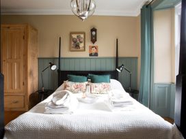 A bedroom with a bed and wardrobe at Grove House in Grange-Over-Sands