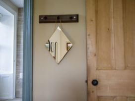 A mirror and a door in a hallway at Grove House in Grange-Over-Sands