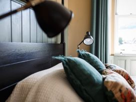 A bedroom with a bed and bedside lamps at Grove House in Grange-Over-Sands