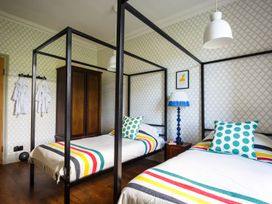 A bedroom with two beds and a wardrobe at Grove House Grange-Over-Sands