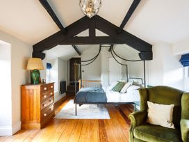 A bedroom with a bed, chair, and dresser at Grove House in Grange-Over-Sands