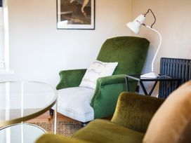 A living room with an armchair and lamp at Grove House in Grange-Over-Sands