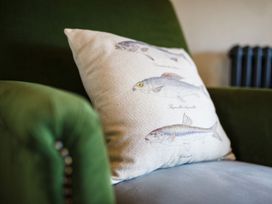 A pillow on a green sofa at Grove House in Grange-Over-Sands