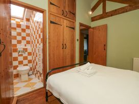 A bedroom with a bed and bathroom entrance at Grove House in Grange-Over-Sands
